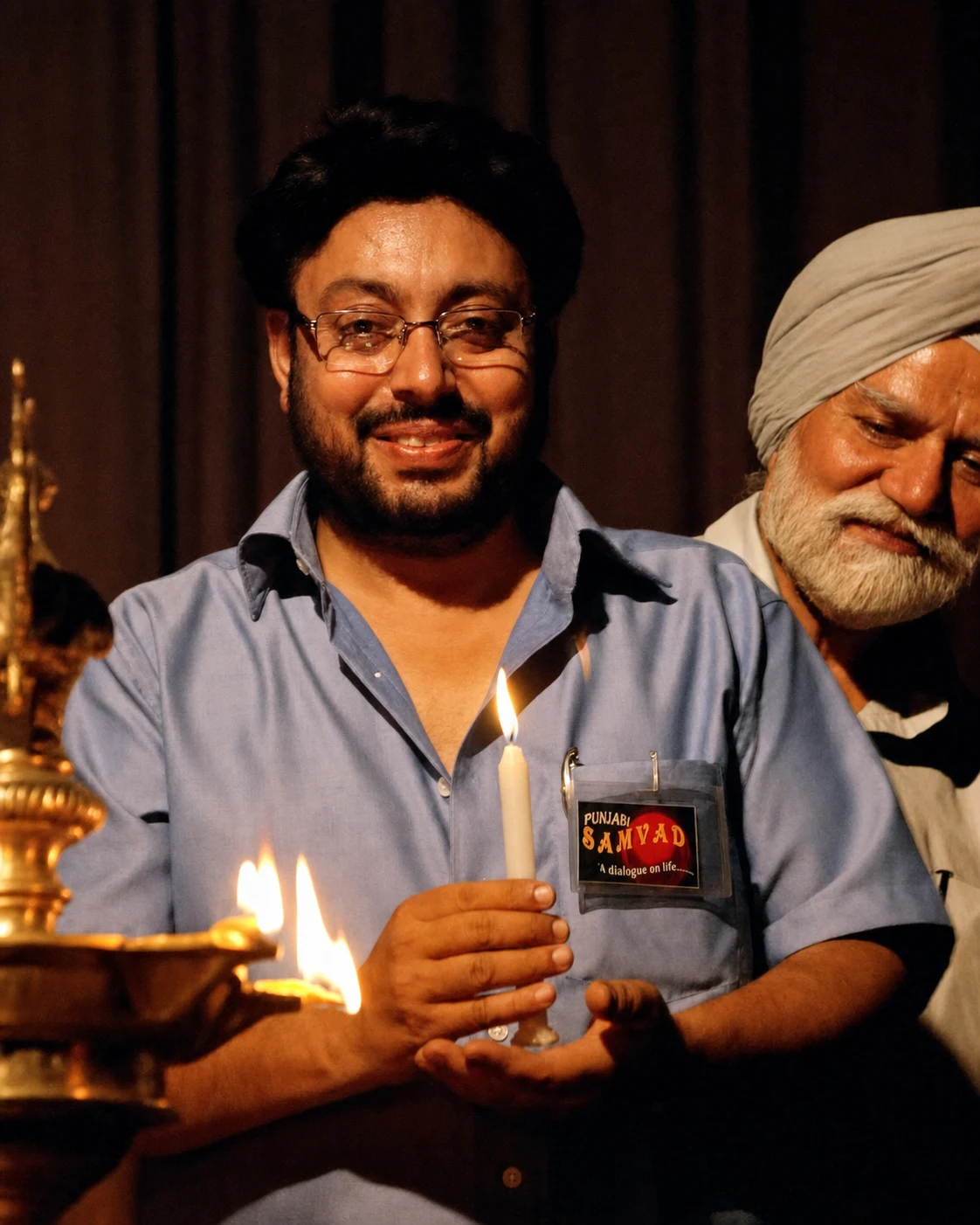 Amit Bawa holding a candle at a Punjabi Samvad programme